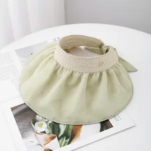Detail of light green pleated brim sun hat with straw crown and bow-knot fastener
