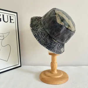 Detail of vintage washed camouflage bucket hat on a wooden stand with trendy decor