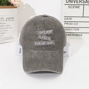 Close-up of distressed gray baseball cap with vintage slogan patches and worn edges