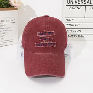 Vintage burgundy baseball cap with blue embroidery patches in a lifestyle setting