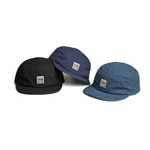 Three vintage 5-panel camper caps in black and blue with embroidered patches