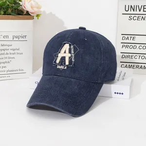 Detailed shot of dark blue washed denim baseball cap with vintage A embroidery and text
