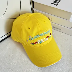 Detail of mushroom embroidery on a bright yellow cotton twill baseball cap with wide brim