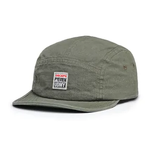 Detail of olive green five-panel camper hat with retro patch and metal side eyelets