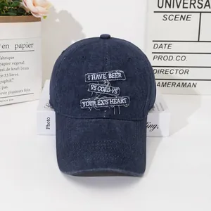 Detail of navy blue washed denim baseball cap with white vintage embroidery lettering