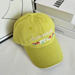 Detail of light green baseball cap with white brim edge and mushroom embroidery