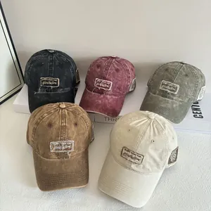 Dettaglio di berretti da baseball vintage in cotone lavato in vari colori con patch ricamate