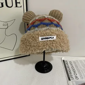 Detail of winter knit hat featuring fuzzy bear ears, geometric patterns, and plush lining