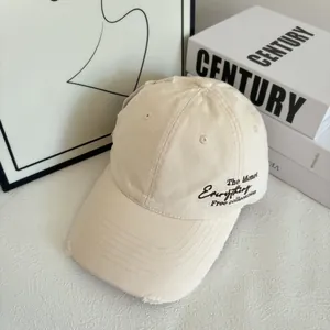 Close-up of beige quick-dry baseball cap featuring side embroidery and distressed brim details