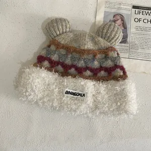 Detail of bear ears knit hat with plush rim and decorative woven stripe patterns