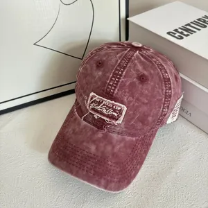 Dettaglio del cappellino bordeaux lavato vintage con toppa consumata ed effetti usurati