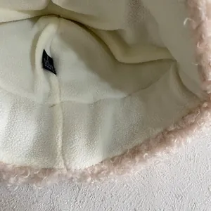 Close-up of pink faux fur hat showing soft plush exterior and warm white fleece lining