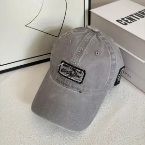 Dettaglio del cappellino da baseball vintage in cotone lavato grigio con toppa ricamata