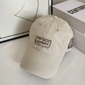 Dettaglio del cappellino vintage beige con toppe consumate e ricami di alta qualità