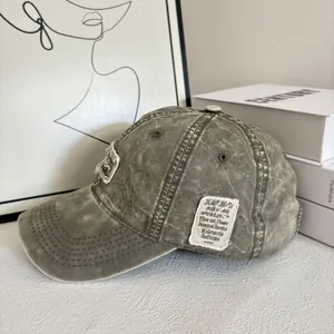 Dettaglio cappellino da baseball vintage verde oliva con toppa con lettere sfilacciata