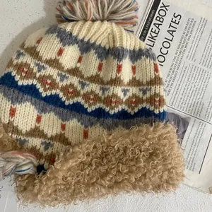 Vue détaillée du bonnet en tricot jacquard avec doublure en laine d'agneau et pompon