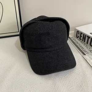 Detail shot of vintage black flat top military cap with foldable ear flaps in washed canvas