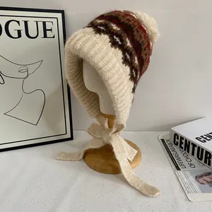 Fair Isle knit trapper hat for women with ear flaps and pom-pom in beige and brown