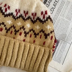 Close-up of Fair Isle knit winter hat with heart pattern on vintage newspaper background
