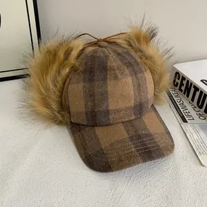 Detailed view of plaid wool baseball cap with brown faux fur earflaps and leather ties