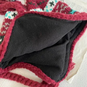 Detailed close-up of thick geometric knit pattern with warm black fleece lining texture