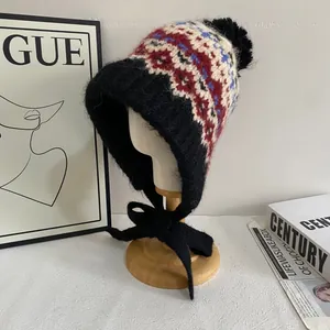 Macro view of Fair Isle pattern knit hat with soft pompom and fleece lining detail