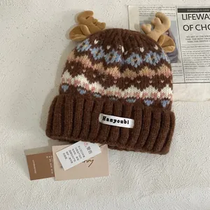 Detalle de gorro de punto estilo Fair Isle con astas de peluche y patrones de copos