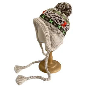 Winter knitted earflap hat with colorful jacquard pattern and plush pompom decoration