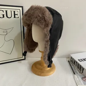Winter faux leather trapper hat with warm brown plush lining on a wooden display stand
