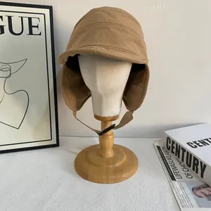 Dettaglio del cappello antivento kaki con paraorecchie e fibbia a scatto regolabile