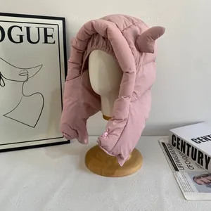 Détail du bonnet d'hiver rose matelassé avec oreilles mignonnes et fermeture à bouton