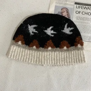 Detalle del tejido de punto del gorro jacquard con golondrinas y protección para orejas