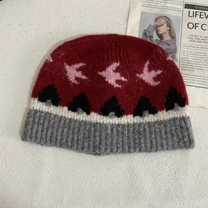 Primer plano detallado de la textura de punto jacquard y patrón de pájaro del gorro de invierno