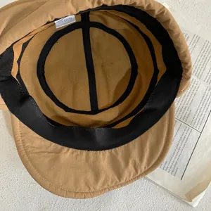 Dettaglio interno del cappello kaki con etichetta 100% nylon e fascia antisudore