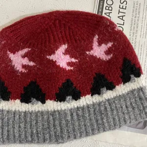 Detalle del gorro de lana de punto con motivo jacquard de aves y puño acanalado