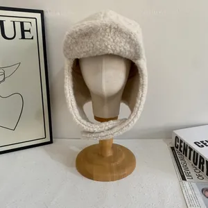 Dettaglio ravvicinato di un cappello da aviatore color crema in shearling sintetico caldo
