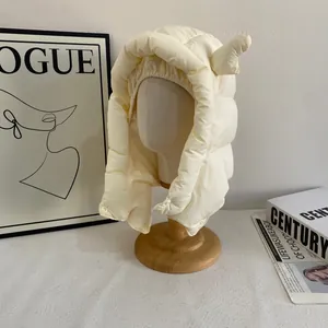 Détail de la chapka thermique beige avec cornes de cerf et fermeture par bouton-pression