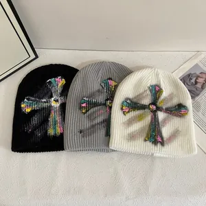Three-pack knitted beanies in black grey and white featuring colorful graffiti crosses