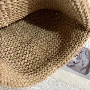 Makroansicht der detaillierten dicken Baumwollstrickstruktur einer beige Handtasche