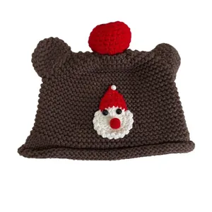 Handgestrickte braune Bärenmütze mit Weihnachtsmann-Motiv und rotem Bommel für Weihnachten
