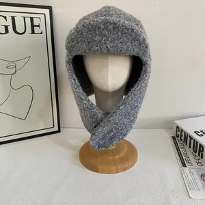 Dettaglio della trama del colbacco grigio lavorato a maglia con paraorecchie in lana