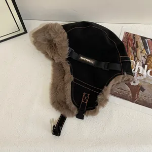 Detalle de gorro de invierno con forro de piel sintética marrón y costuras naranjas