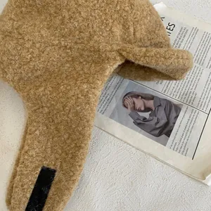 Dettaglio del cappello da aviatore in lana di agnello cammello con pile e nastro nero