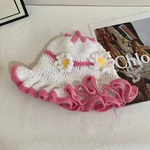 Detailed close-up of handmade white and pink crochet bucket hat with floral daisy details