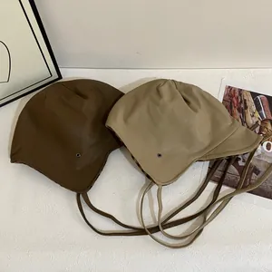 Fleece lined faux leather trapper hat with leopard print and long drawstrings