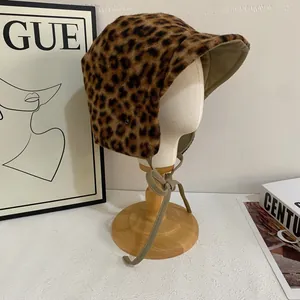 Detail showing plush leopard print trapper hat with leather lining and tie straps
