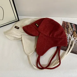 Collezione di cappelli invernali con paraorecchie in rosso e panna con lacci