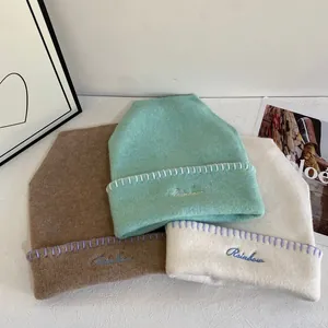Primer plano de gorros de punto con bordado Rainbow y detalles de costuras hechas a mano