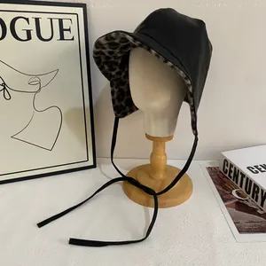 Faux leather winter trapper hat with leopard print fur lining and ear flaps