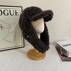 Detail of dark brown plush trapper hat with soft faux fur and warm ear flaps for winter